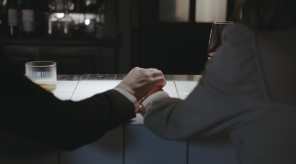 婚活サイトで知り合った女性をバーに連れていき、女性の手を握る男